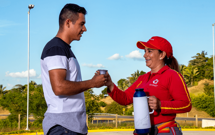 Vendedora de combustible ofreciendo tinto a conductor